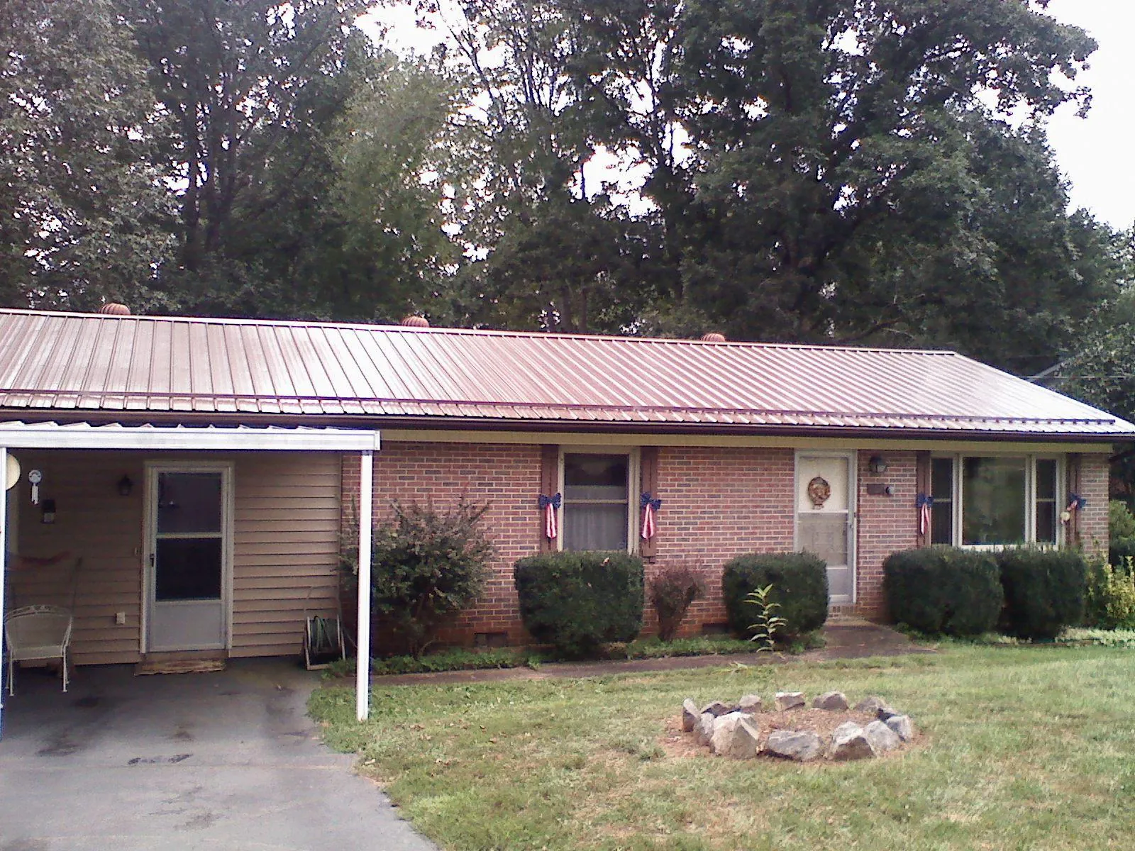 Bronze metal roof and carport on a brick ranch home — Roof Repair work by our crew in Pine Valley